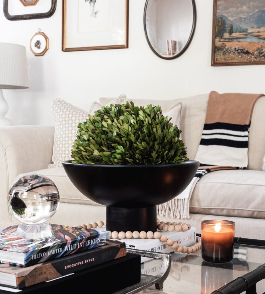 A decorated living room with frames on the wall and a styled coffee table