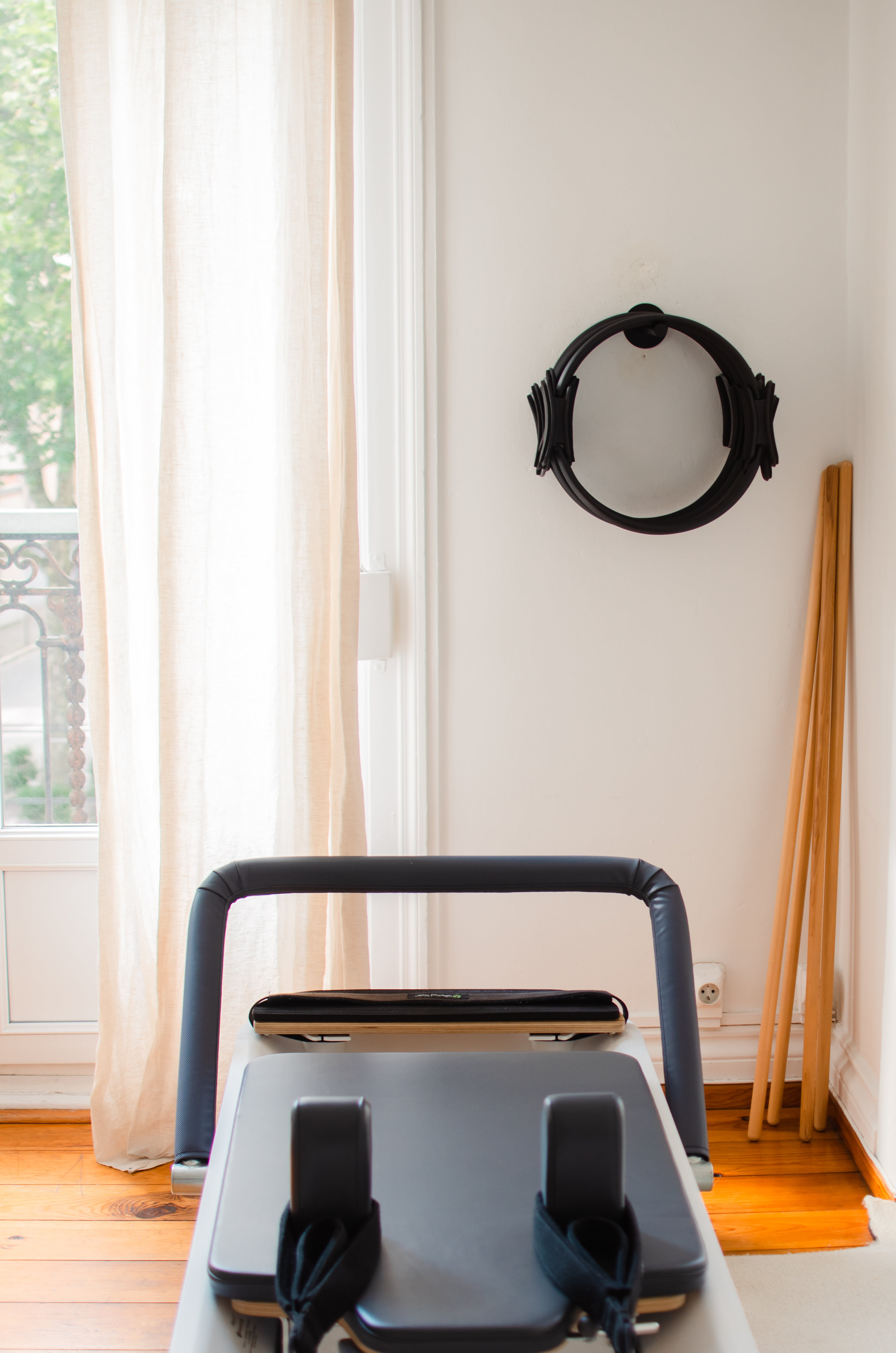Reformer, cercle magique de Pilates et barres en bois dans un coin épuré du studio Healthilona