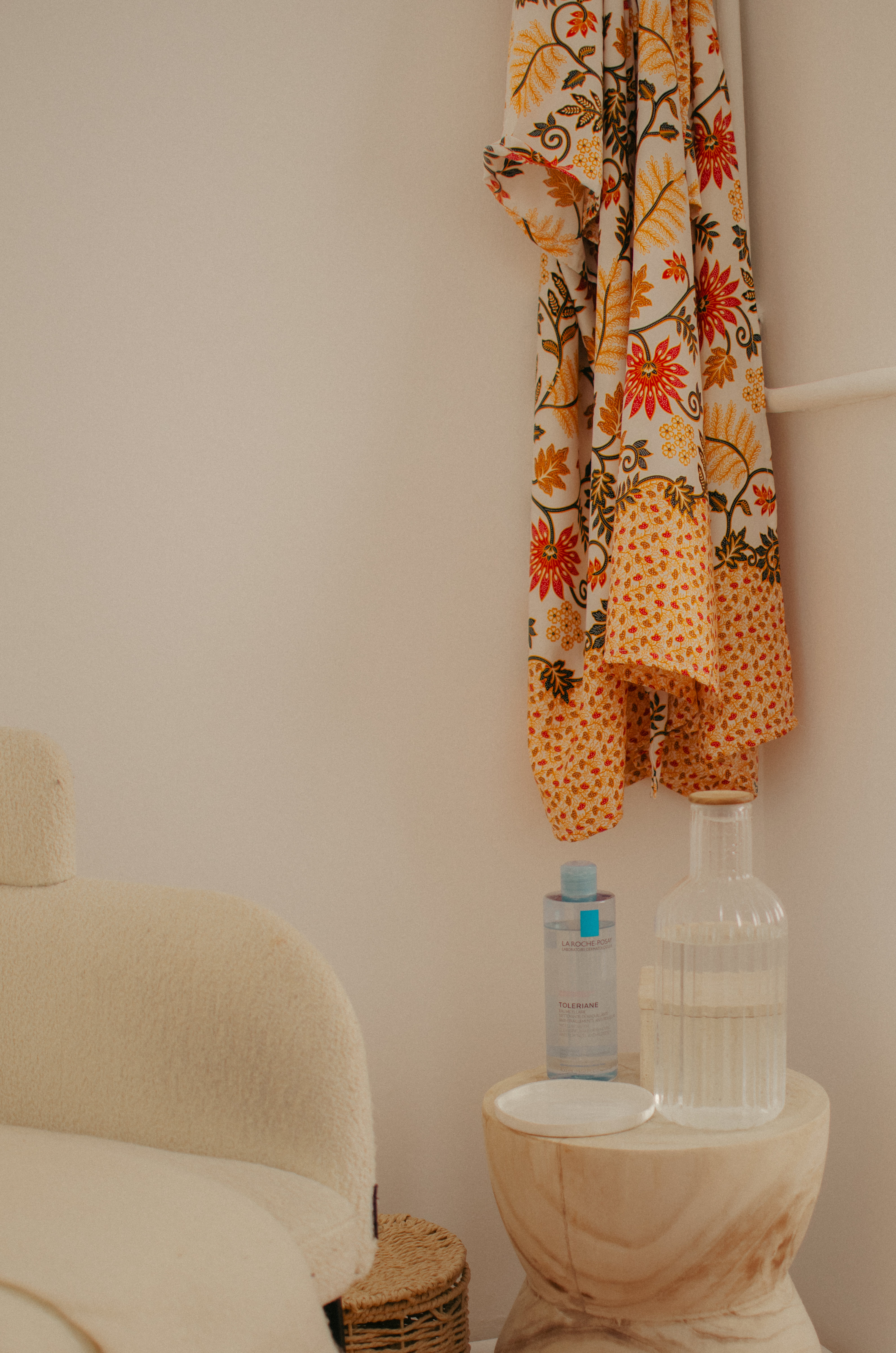 Fauteuil bouclé crème et guéridon avec produits démaquillants La Roche-Posay, coin détente de la cabine de soin