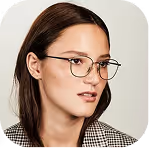 Young woman wearing eyeglasses and a checkered blazer looking to the side against a plain background.