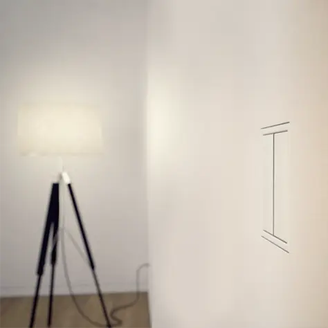 Sfeervolle hoek van een kamer met een moderne vloerlamp met drie poten en een witte lampenkap.