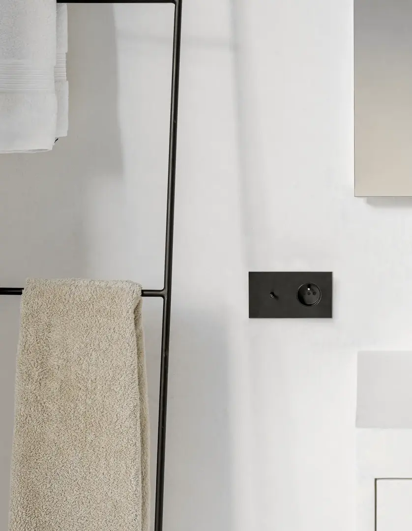 Understated badkamer met schakelaar-stopcontact combinatie in zwart staal.