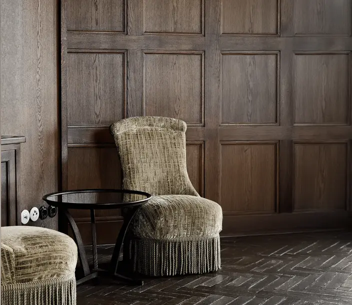 Klassiek interieur met hoge lambrisering in donker hout en olijfkleurige cocktail stoeltjes met op de wand klassiek wit en zwart schakelmateriaal