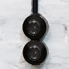 een dubbel uitgevoerde zwarte Hager-Berker opbouw draaischakelaar uit de 1930 serie op een wit marmeren achtergrond