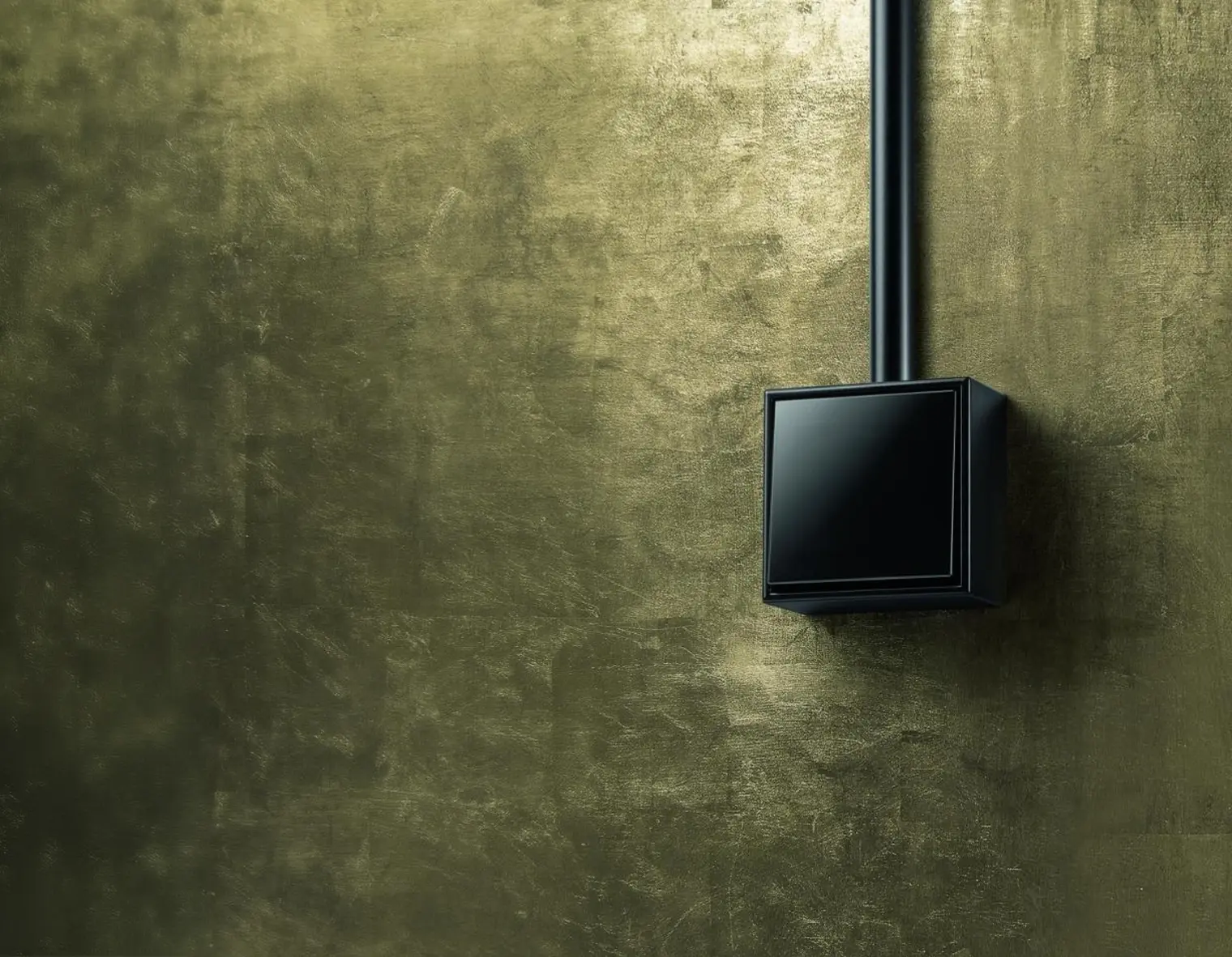 een gouden wand met een glanzend zwarte Gira LS Cube opbouw schakelaar