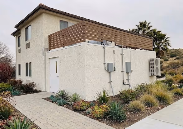 Modular commercial kitchen with a wooden fenced rooftop patio attached to a house.