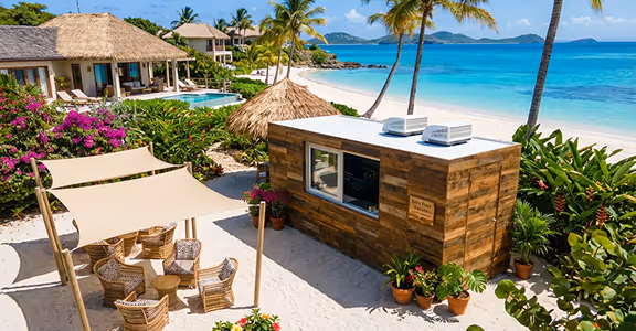 Beachside wooden bar with wicker chairs and tables under shade near a tropical resort and ocean.