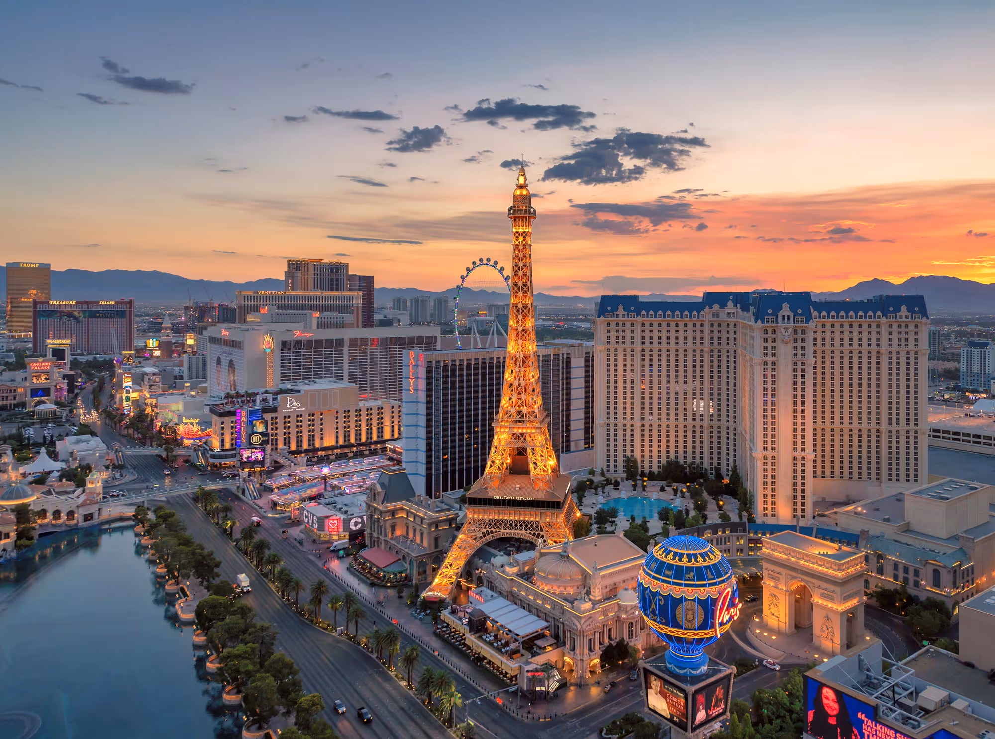 Las Vegas Strip at sunset with illuminated Eiffel Tower replica and Paris hotel.