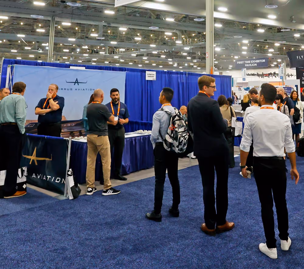 People conversing and walking around the busy exhibit hall at 2025 NBAA-BACE