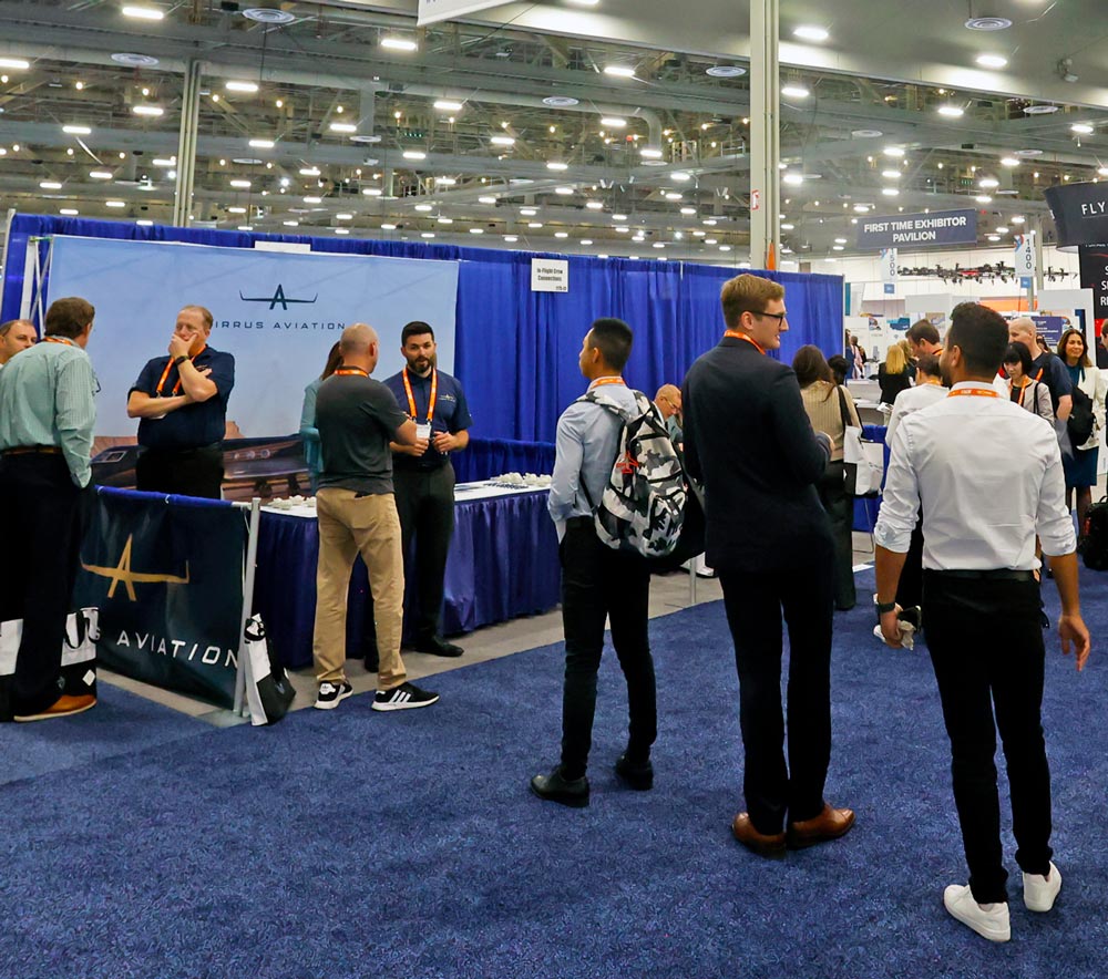 People conversing and walking around the busy exhibit hall at 2025 NBAA-BACE