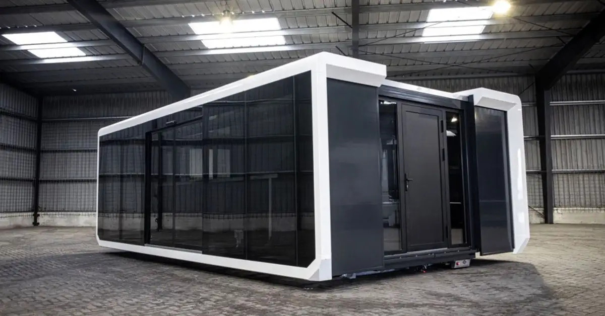MRA Mobile Experiential black and white modular container with large tinted windows inside a warehouse