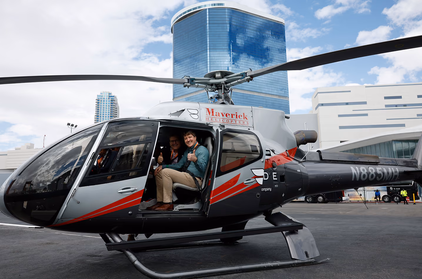 Two men sitting inside a Blade hHelicopter aircraft with thumbs up ourside the Las Vagas Convention center at 2025 NBAA-BACE