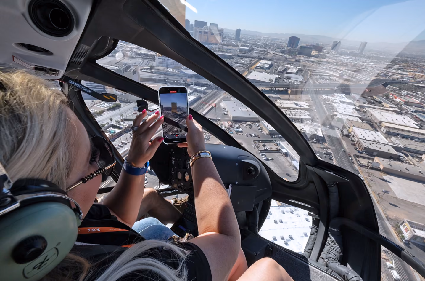Person inside Blade helicopter in flight taking a photo of Las Vegas with their phone