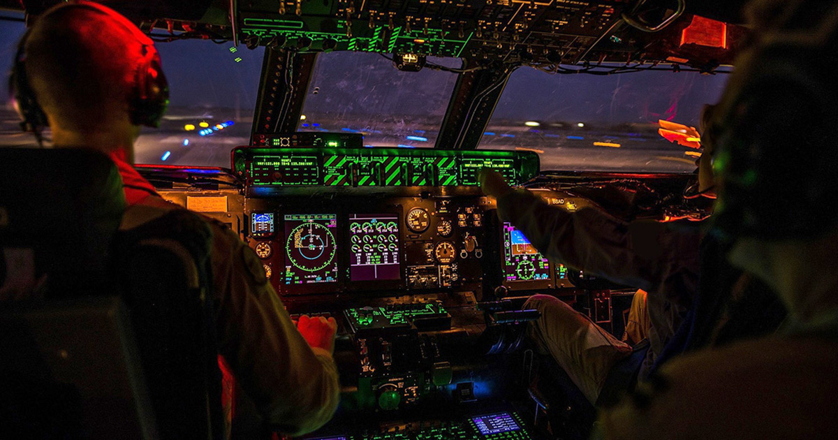 Flight crew on a dark flight deck at night
