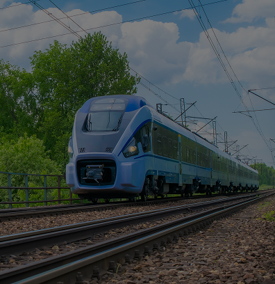Un train de passagers moderne bleu et blanc circulant sur des voies ferrées sous un ciel partiellement nuageux.