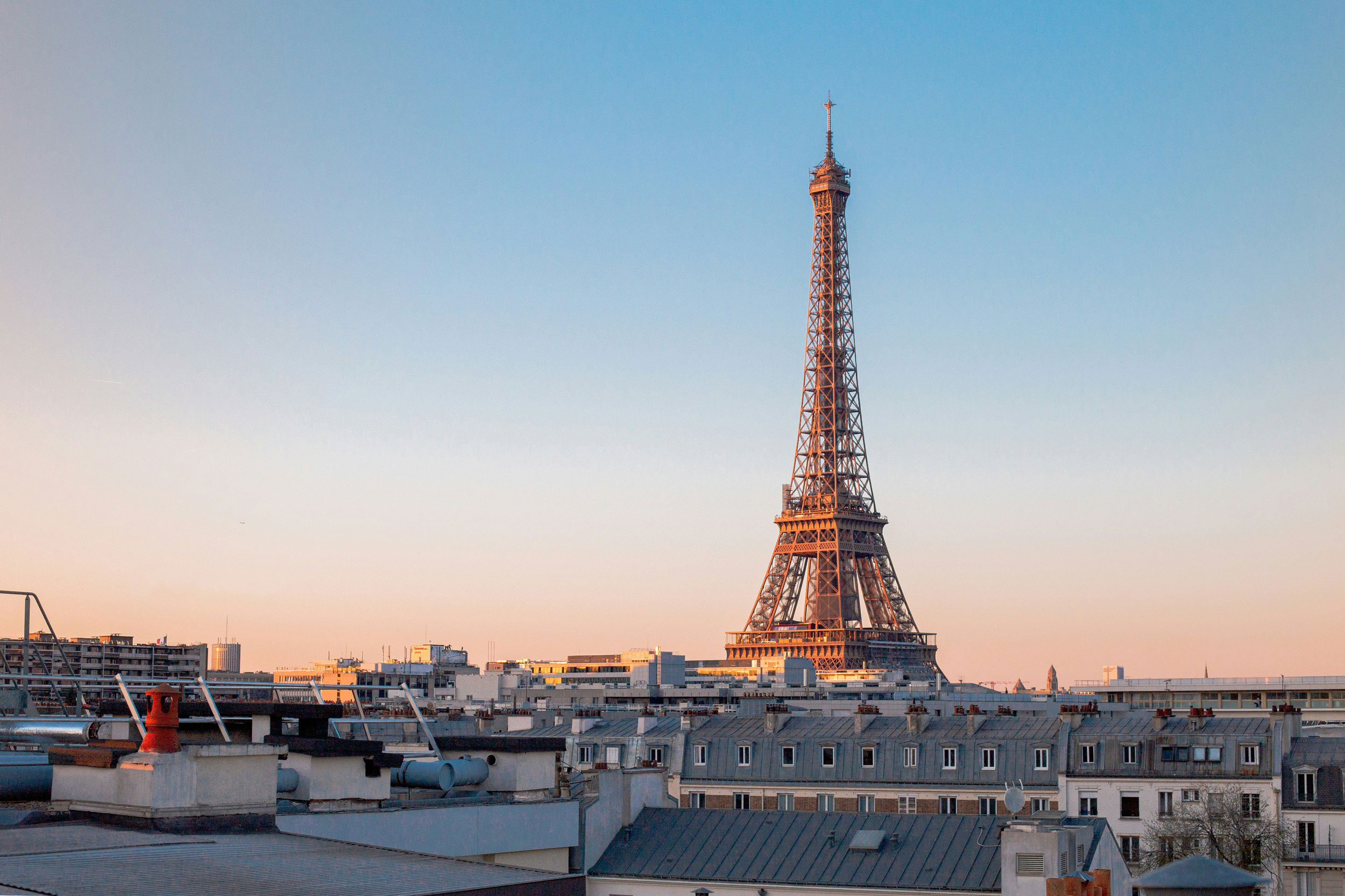 La Torre Eiffel al tramonto vista dai tetti di Parigi.