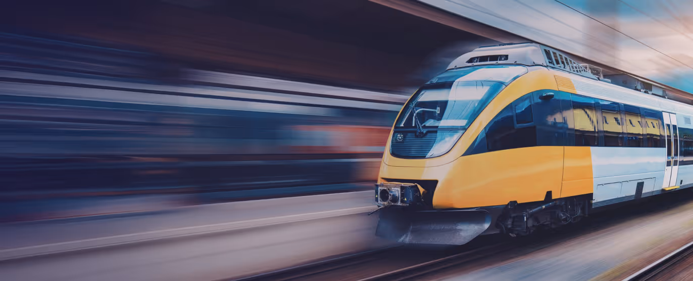 Yellow and white high-speed train moving rapidly on tracks with motion blur background.
