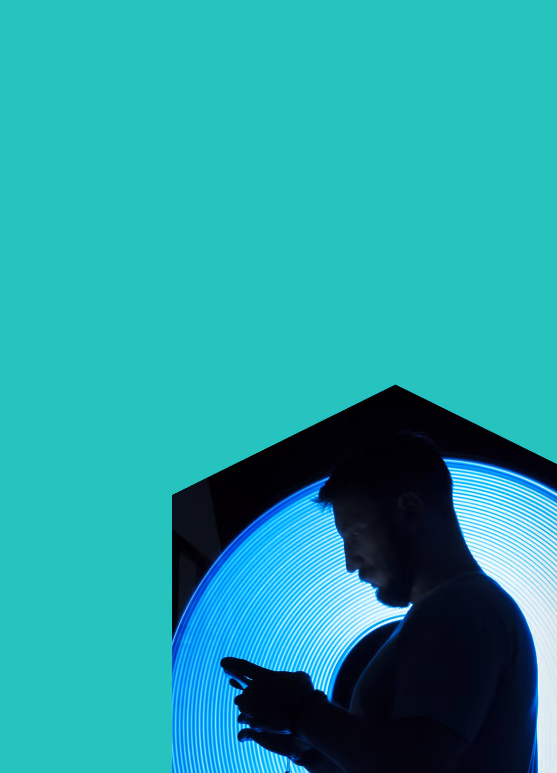 Silhouette of a man using a smartphone in front of a glowing blue circular light.