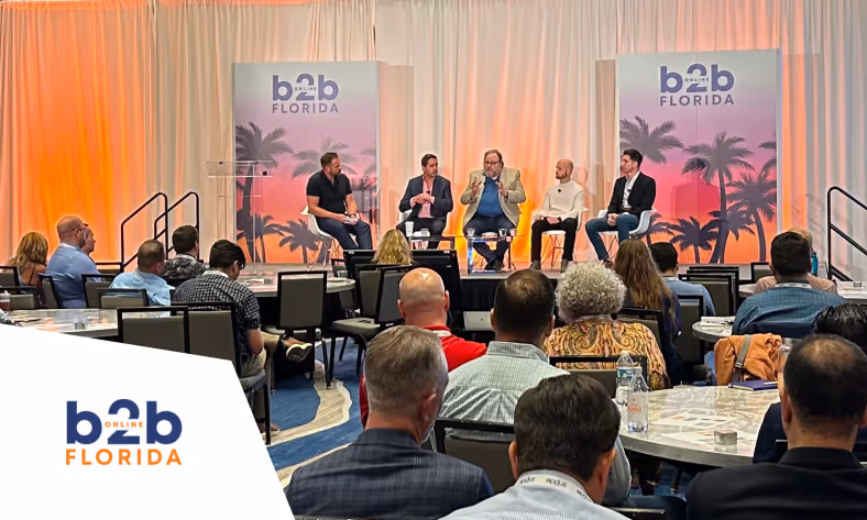 Panel discussion at b2b Online Florida event showing five speakers seated on stage with an audience watching.