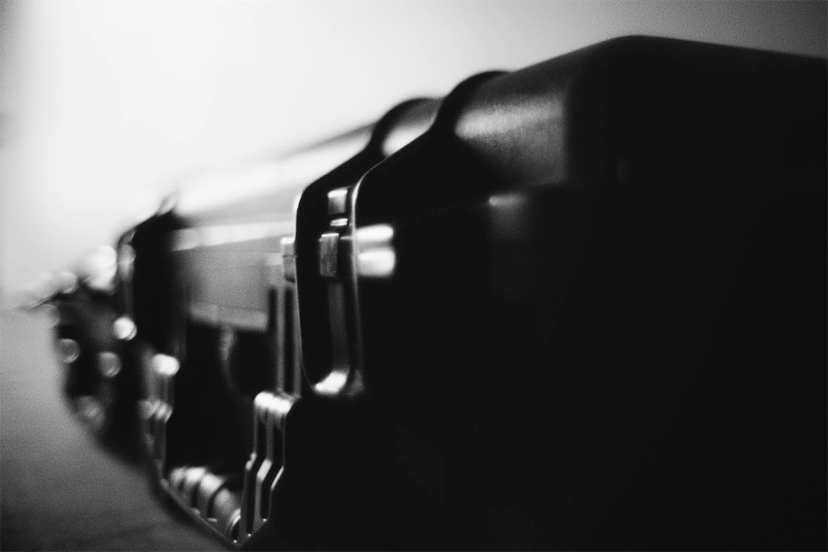 Close-up of black hard case latches with shallow depth of field in black and white.