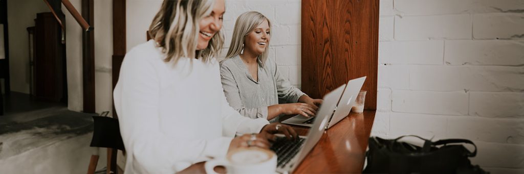Two women working on their laptops