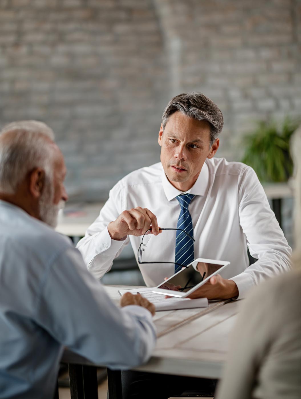 Financial advisor showing a client a small tablet