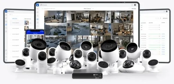 Several security cameras are displayed in front of screens showing surveillance footage from different locations.