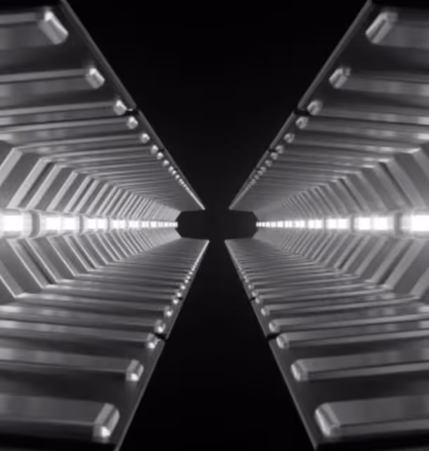 Symmetrical view looking up a modern building's geometric facade with repeating lighted structures.