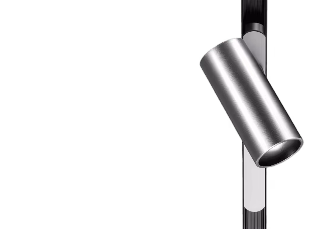 Modern cylindrical silver spotlight attached to a vertical black track lighting rail.