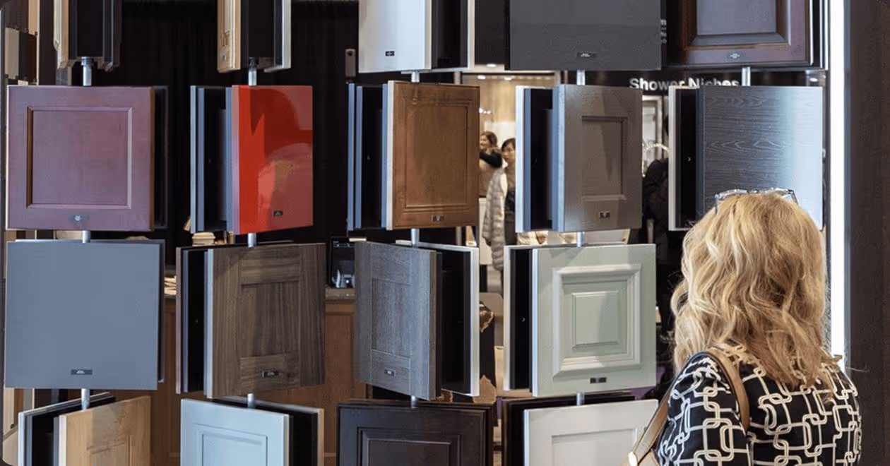 Woman viewing a display of various cabinet door samples in different colors and finishes.