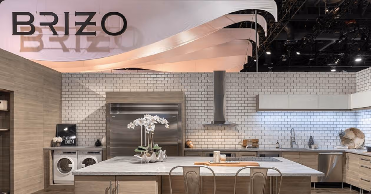 Modern kitchen with stainless steel appliances, white subway tile backsplash, and a large marble island with chairs.