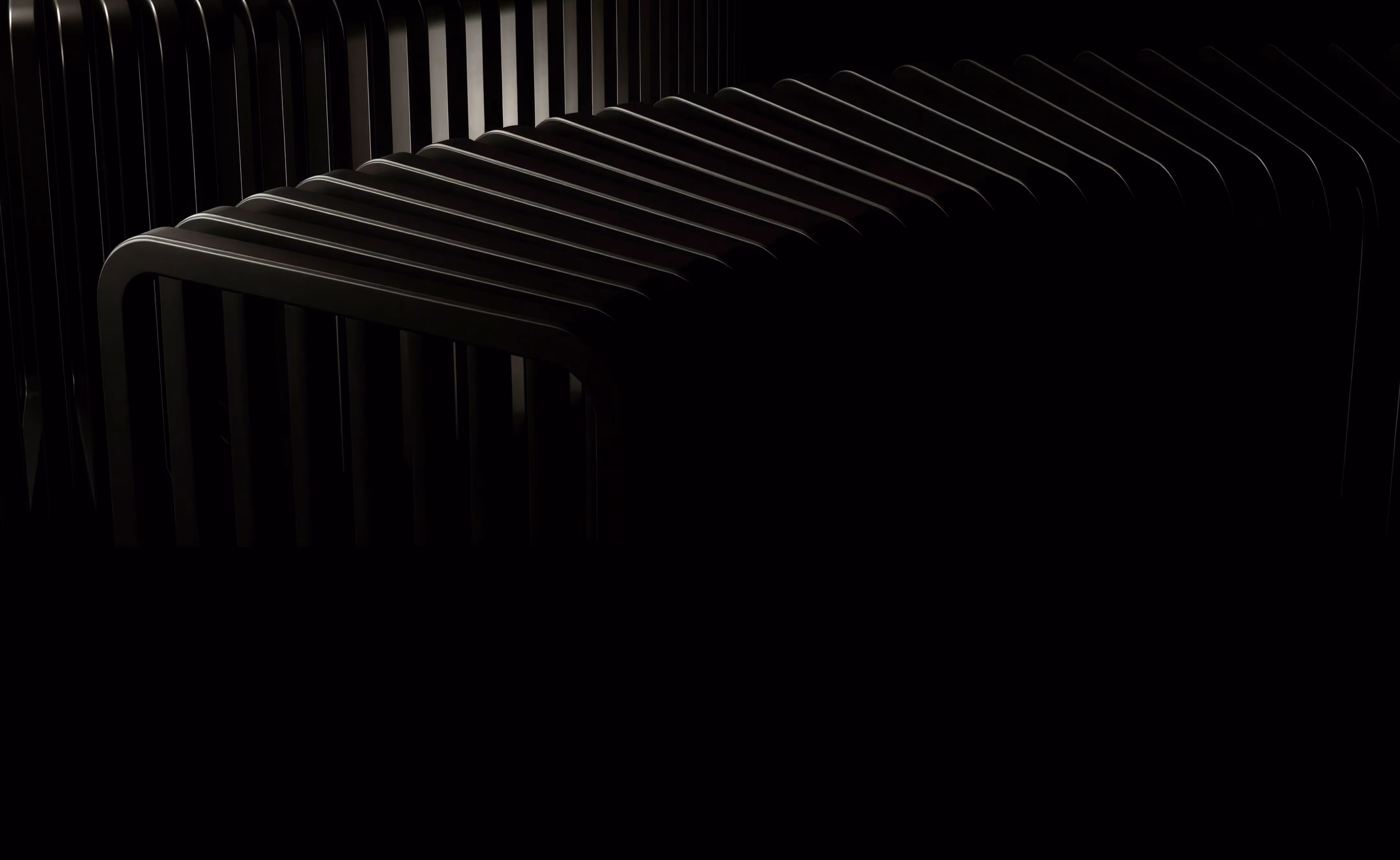 Dark abstract close-up of curved black slats arranged in a repetitive pattern.