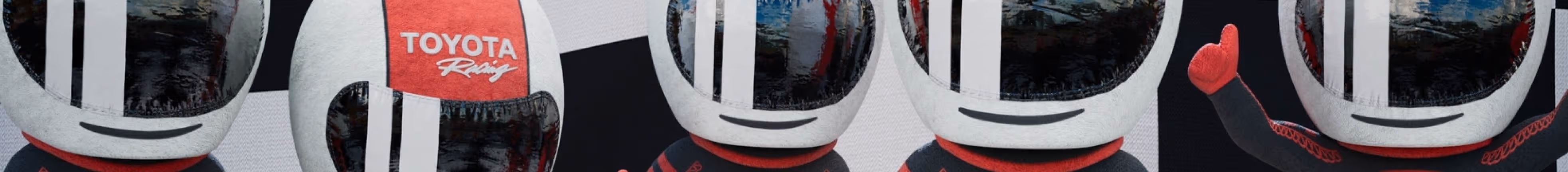 Five small plush figures wearing white racing helmets with black stripes, one helmet has a red Toyota Racing logo.