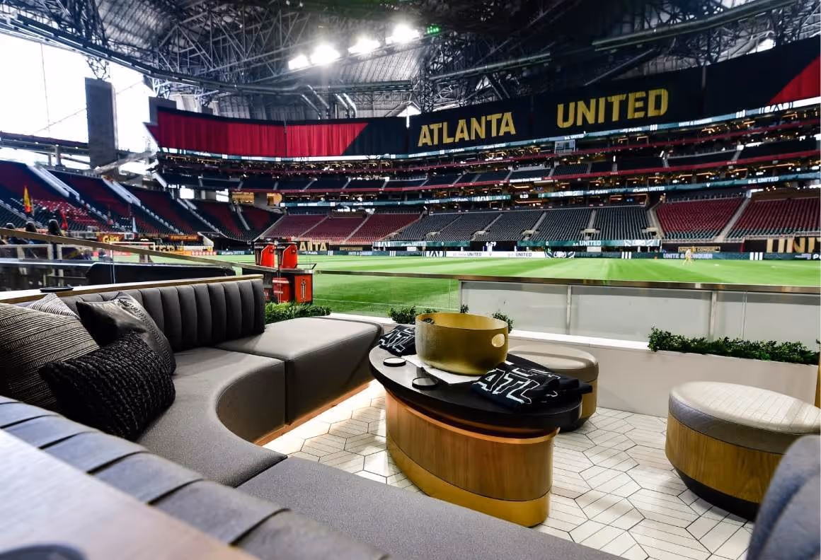 Luxury suite seating with table inside Atlanta United stadium overlooking the soccer field.