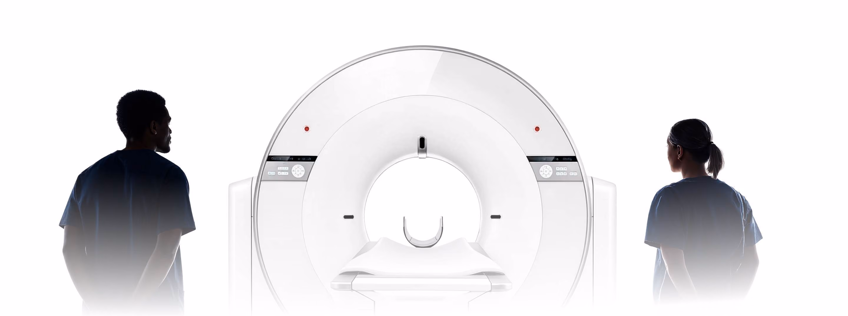 Two healthcare professionals stand on either side of a large medical imaging scanner with a sliding patient table.
