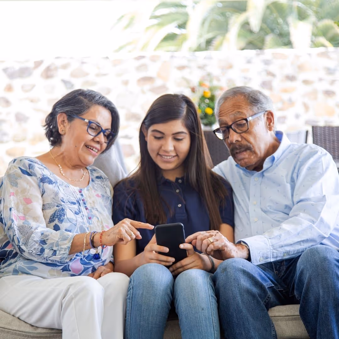 two grandparents with an older granddaughter seated between them