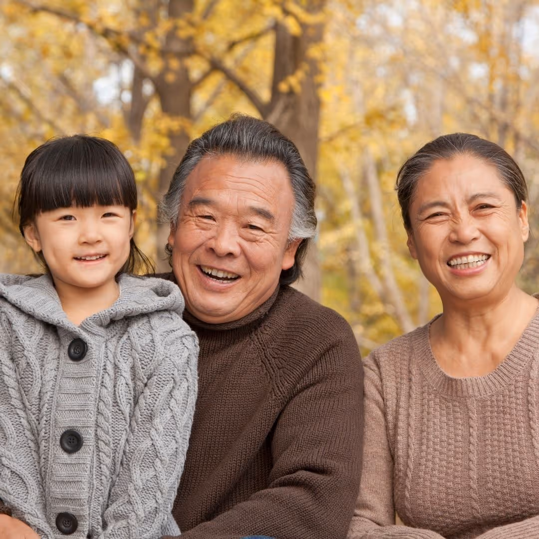 grandparents posing with their granddaughter