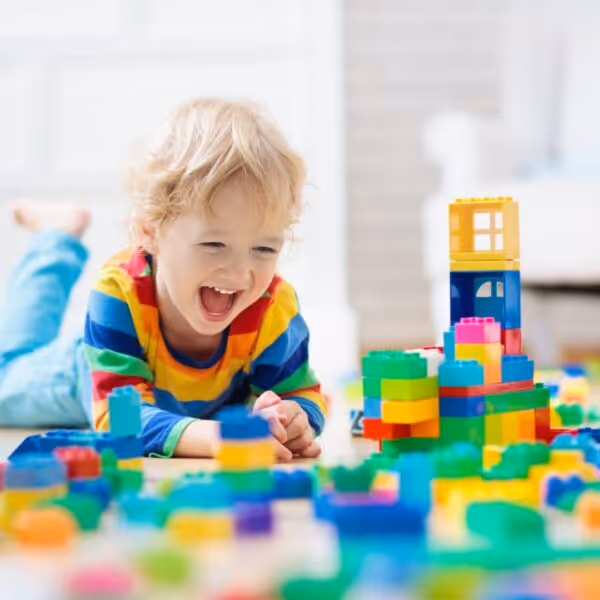 little boy is excited playing with blocks