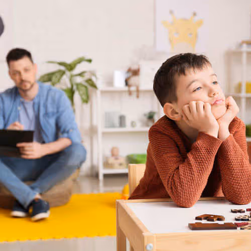therapist taking notes on child behavior