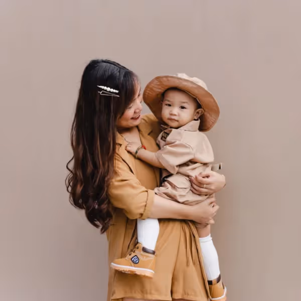 a child looking away from their mother while they are being held