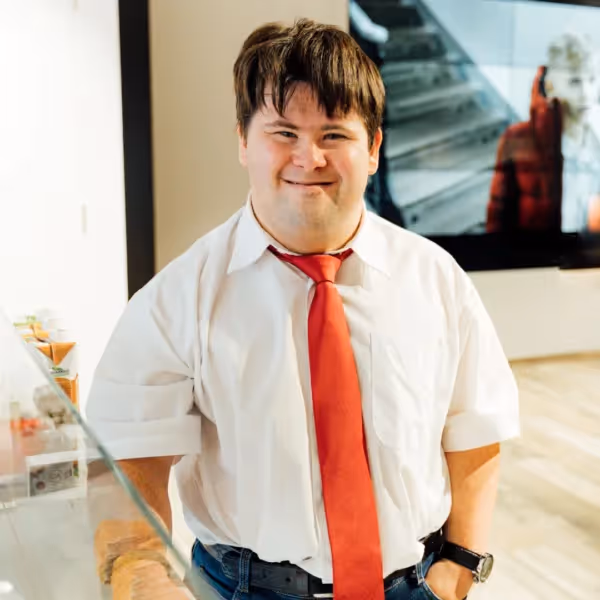a person with autism in a business, smiling