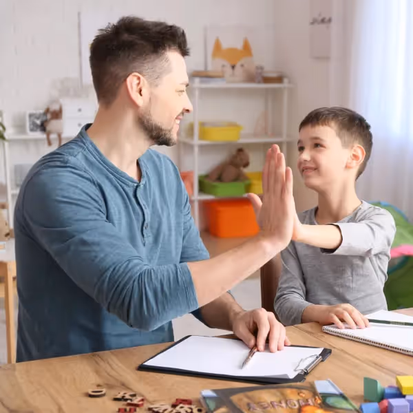 a person and a child high-fiving in a room with toys