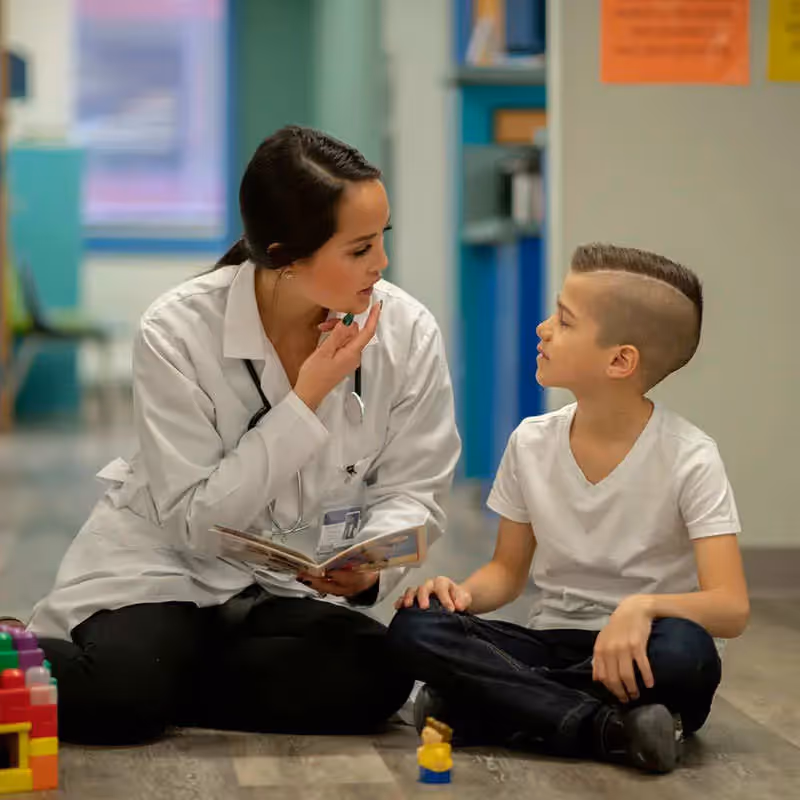 A person working with a child on word pronunciation