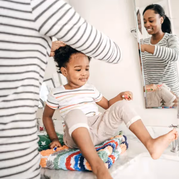 a child and mother getting ready together in the morning
