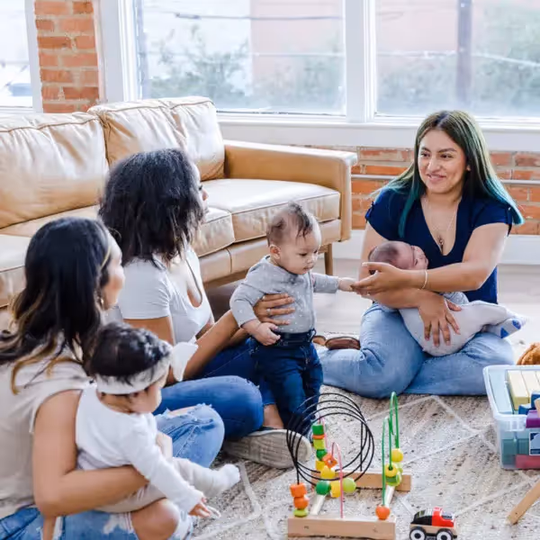 a group of mothers talking together at a home