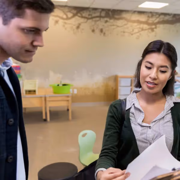 a parent and teacher going over paperwork together