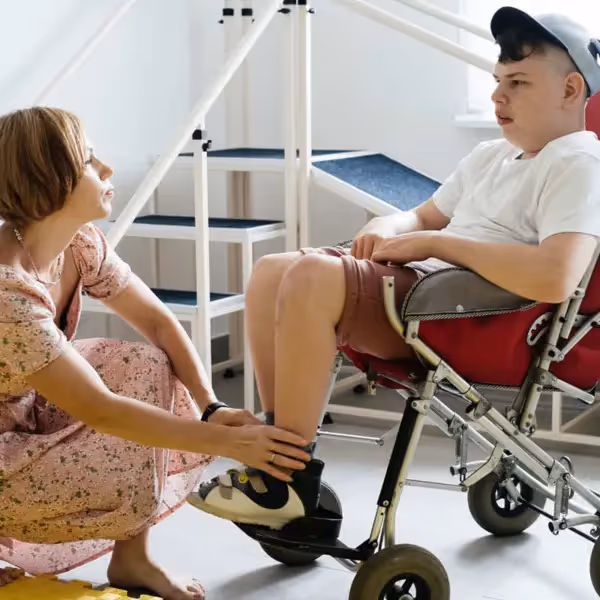 a teacher helping an autistic student in a wheelchair