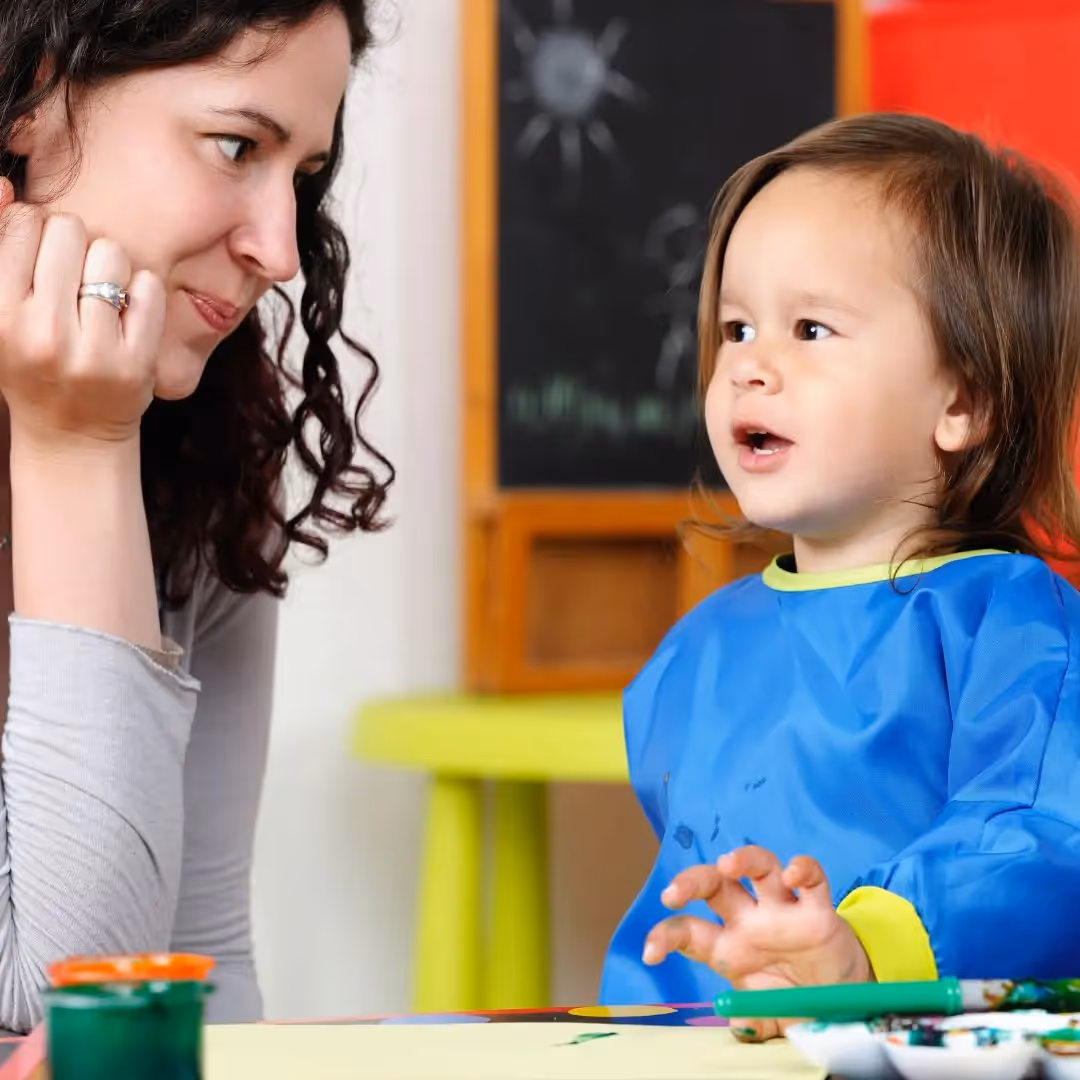 Young child talking to a caregiver.