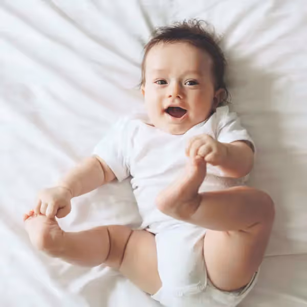 a baby happily playing with its feet