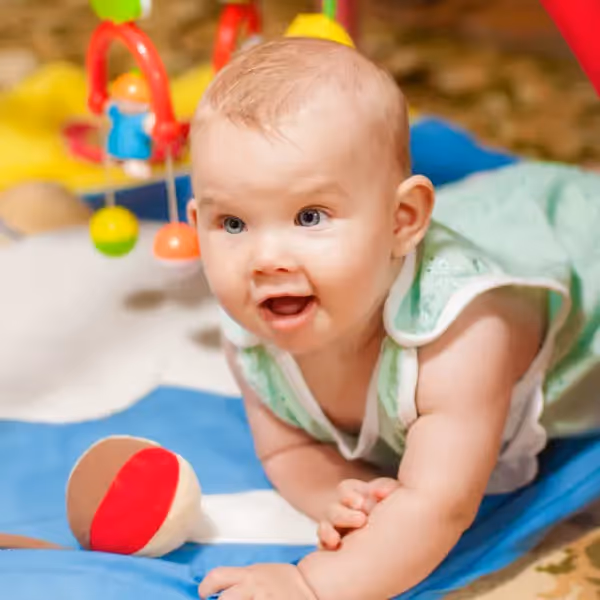a baby playing on a baby activity mat